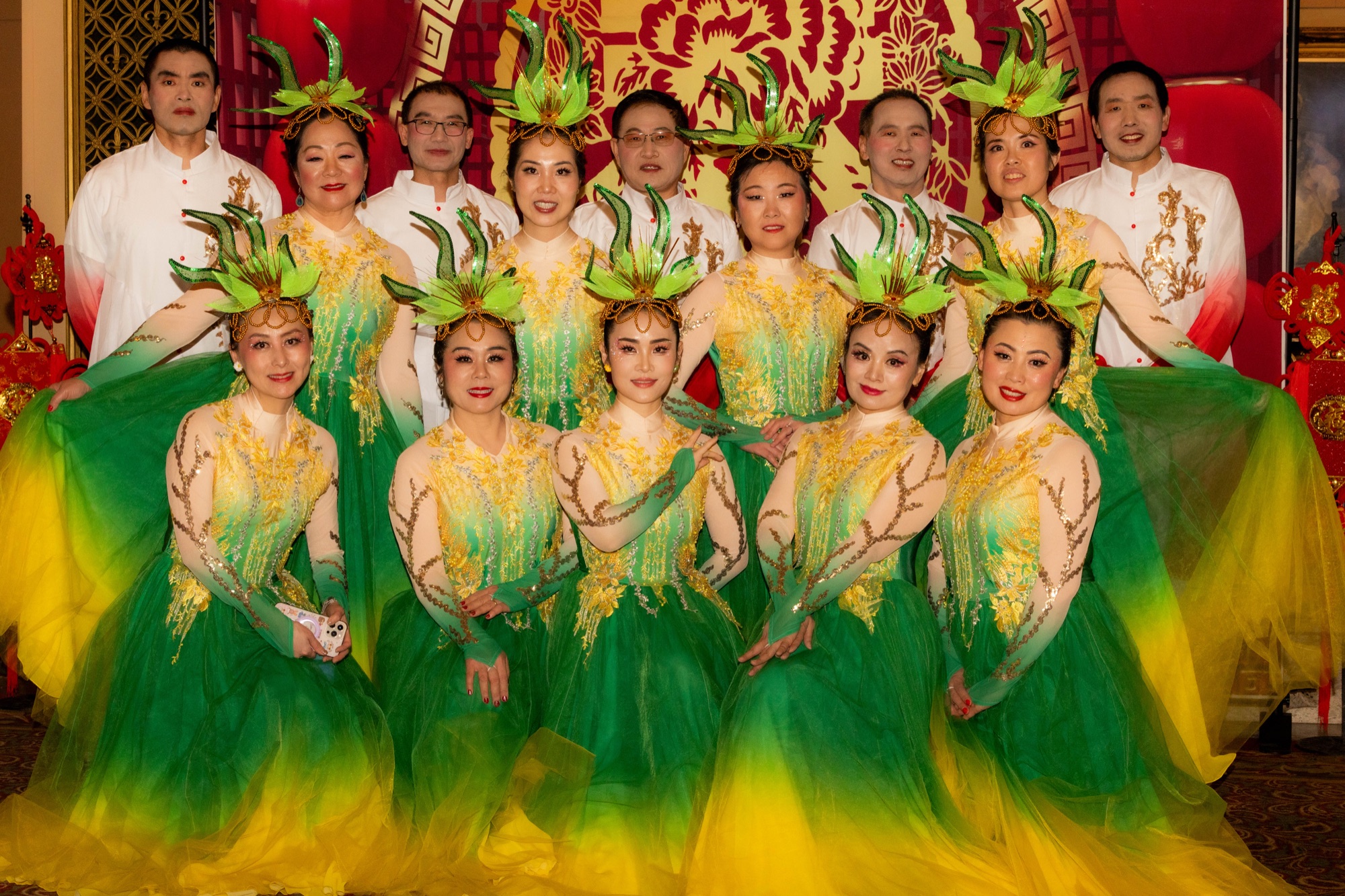 New Year performers in coordinated green, gold, and white costumes