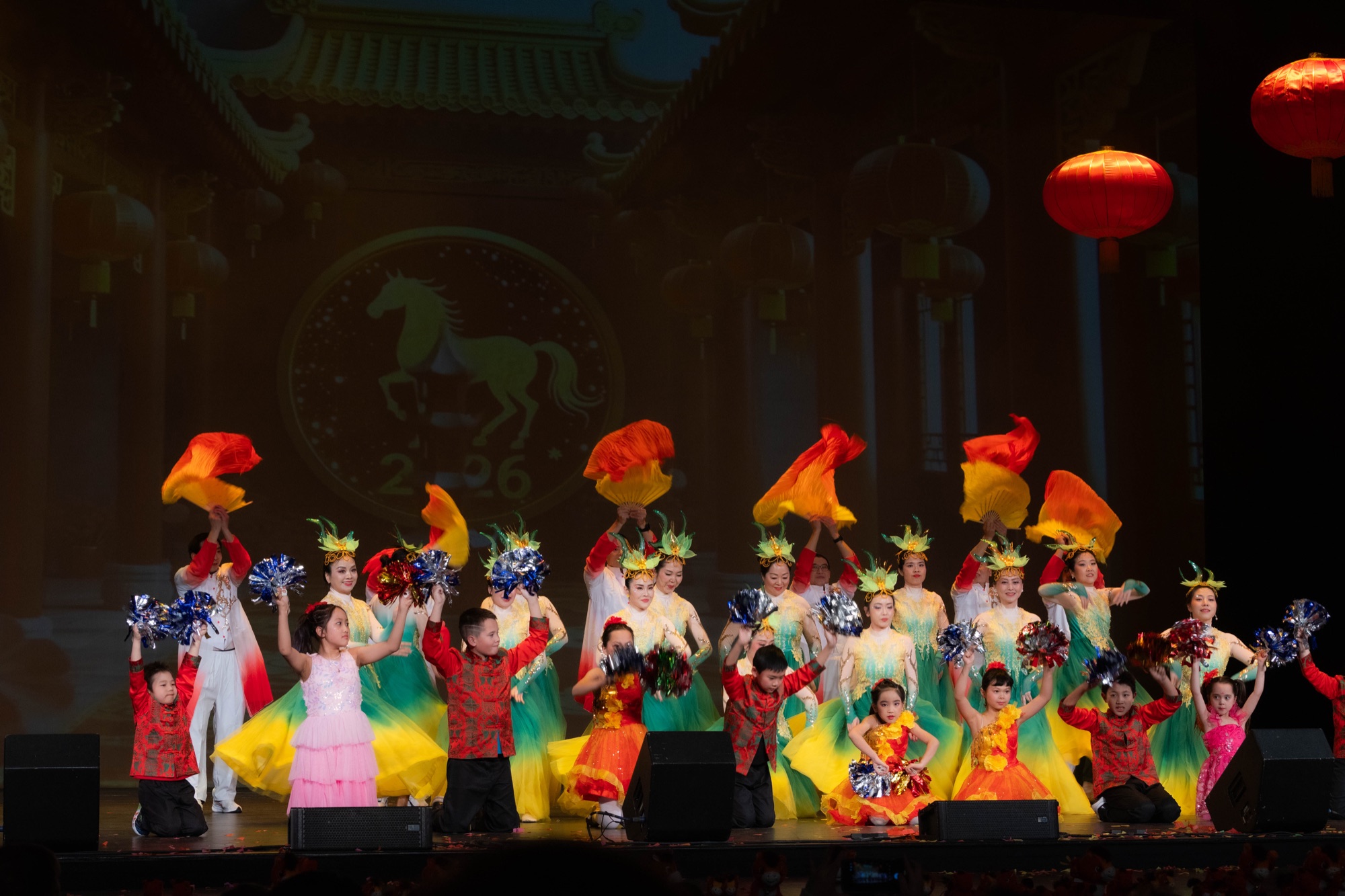Performers across a theater stage during a New Year finale